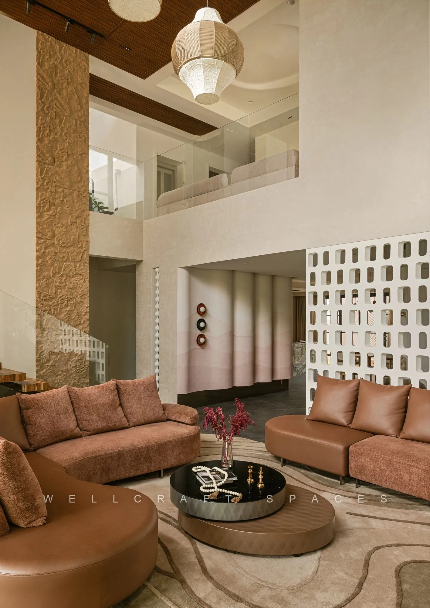 Formal living room with terracotta leather sofas around a low black stone coffee table, a jaali screen partition and a curved cream rug.