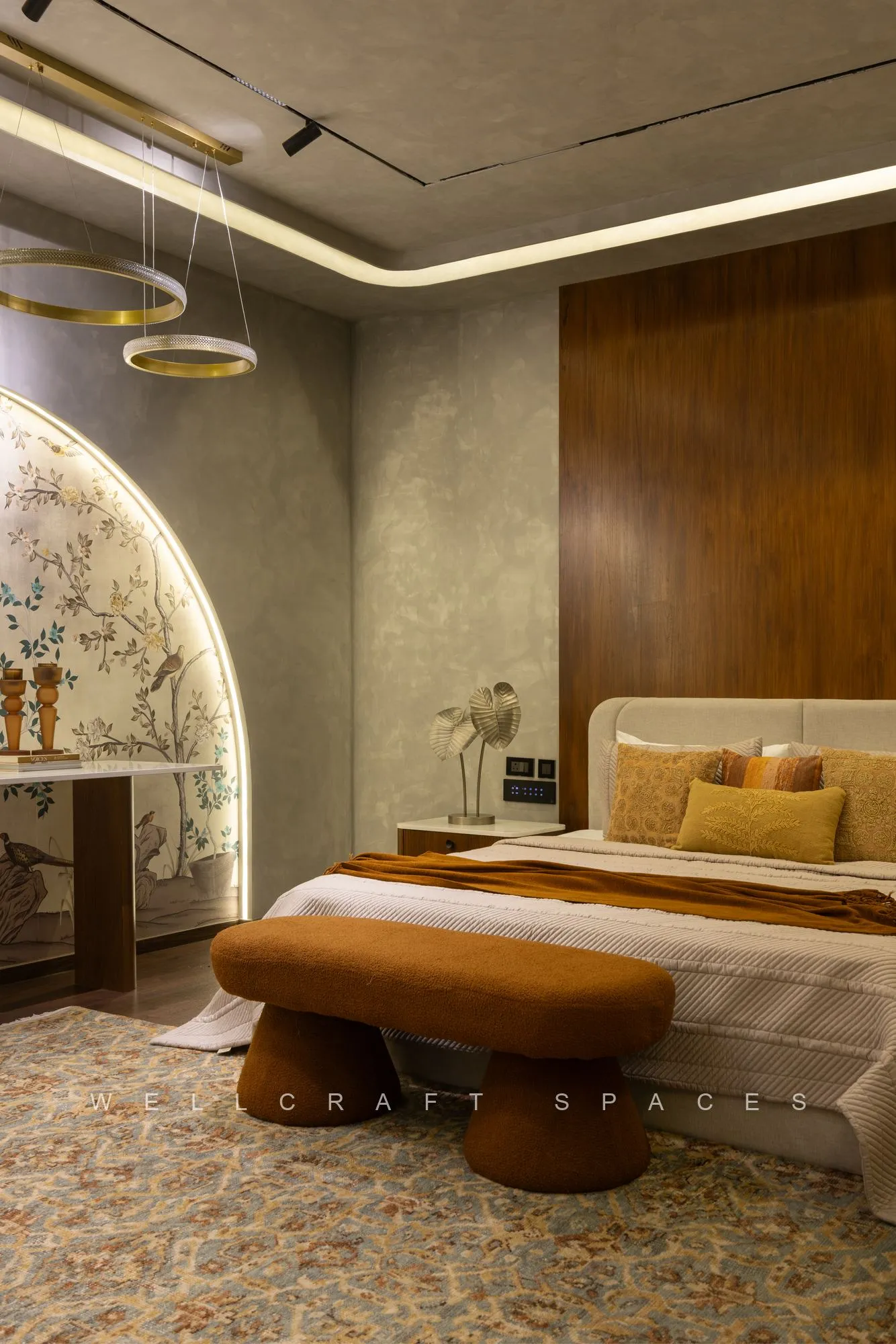 Bedroom ceiling with a cove light channel and a cluster of ring pendant lights, above a walnut headboard wall and an arched hand-painted mural niche.