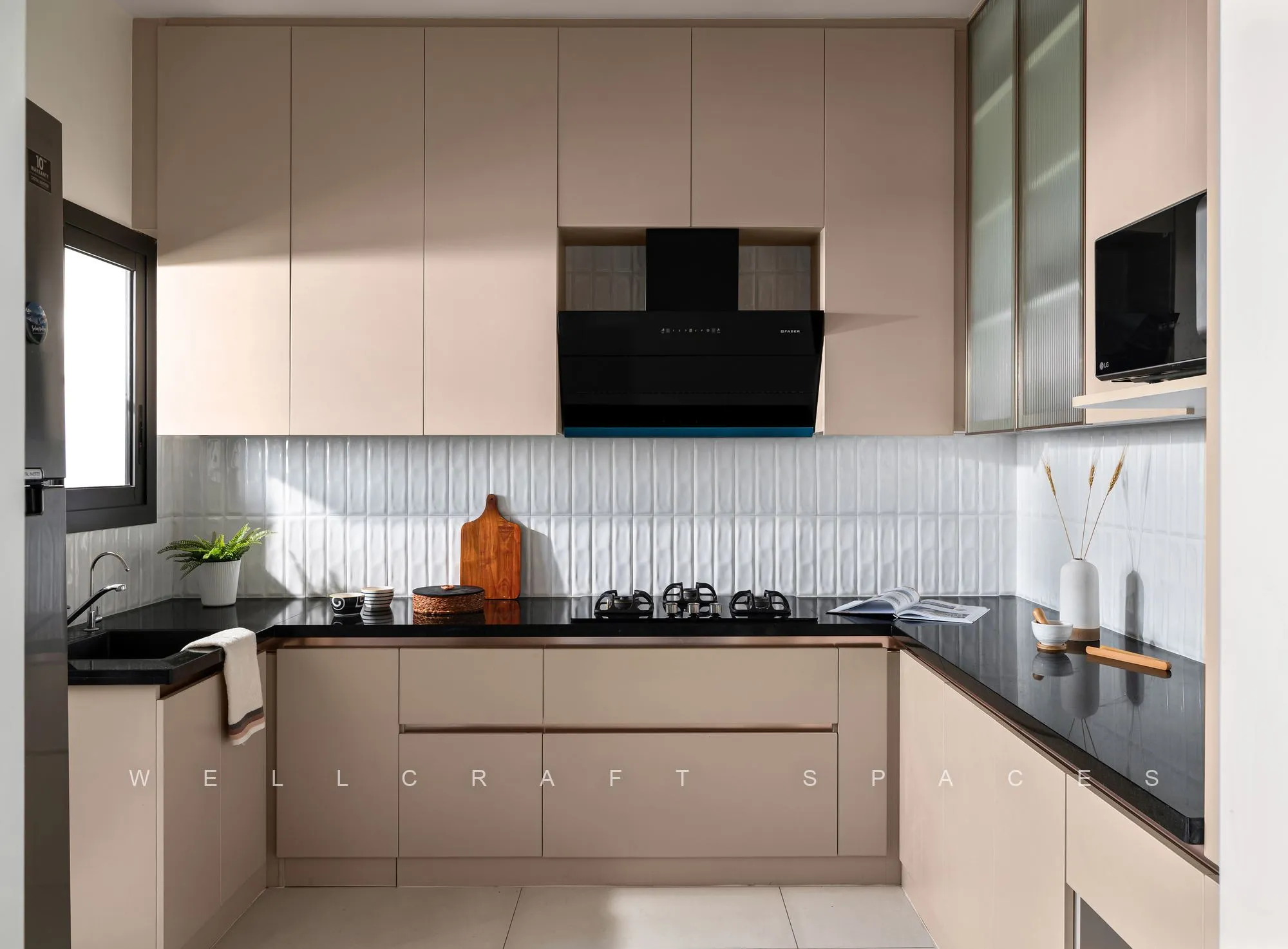 L-shaped kitchen in blush laminate with black granite counters, a ribbed tile backsplash and a window over the hob run.