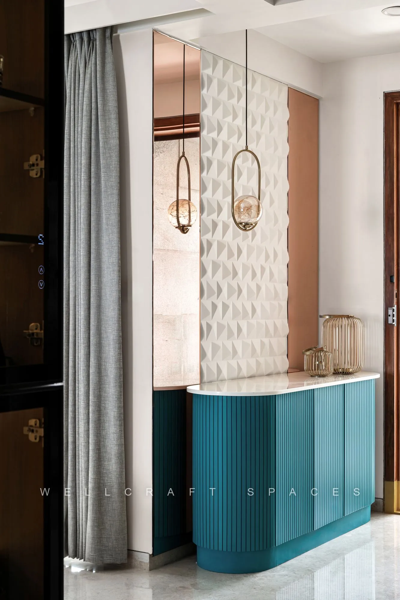 Washbasin console in fluted teal lacquer with a marble top, set against a white three-dimensional textured tile wall beside floor-length grey drapes.