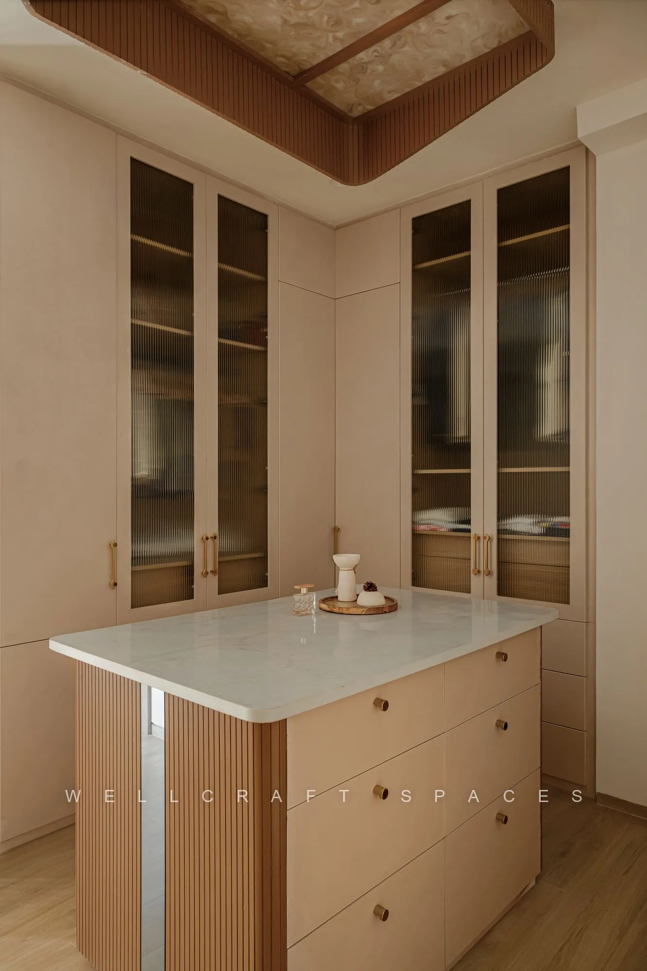 Kitchen with a freestanding island in pale timber, glazed upper cabinets, drawer storage and an oak floor.