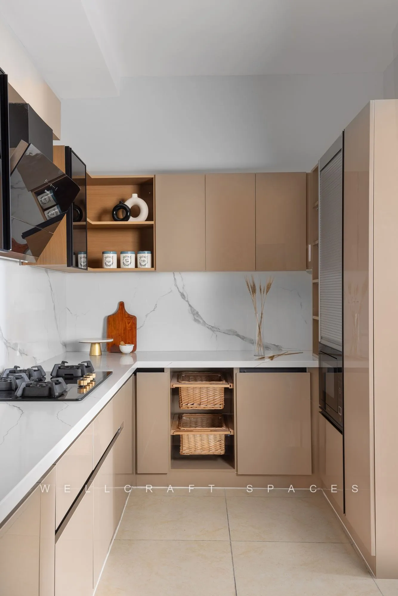Blush-beige handleless modular kitchen with a marble-veined backsplash, open oak shelving and a built-in oven tower.