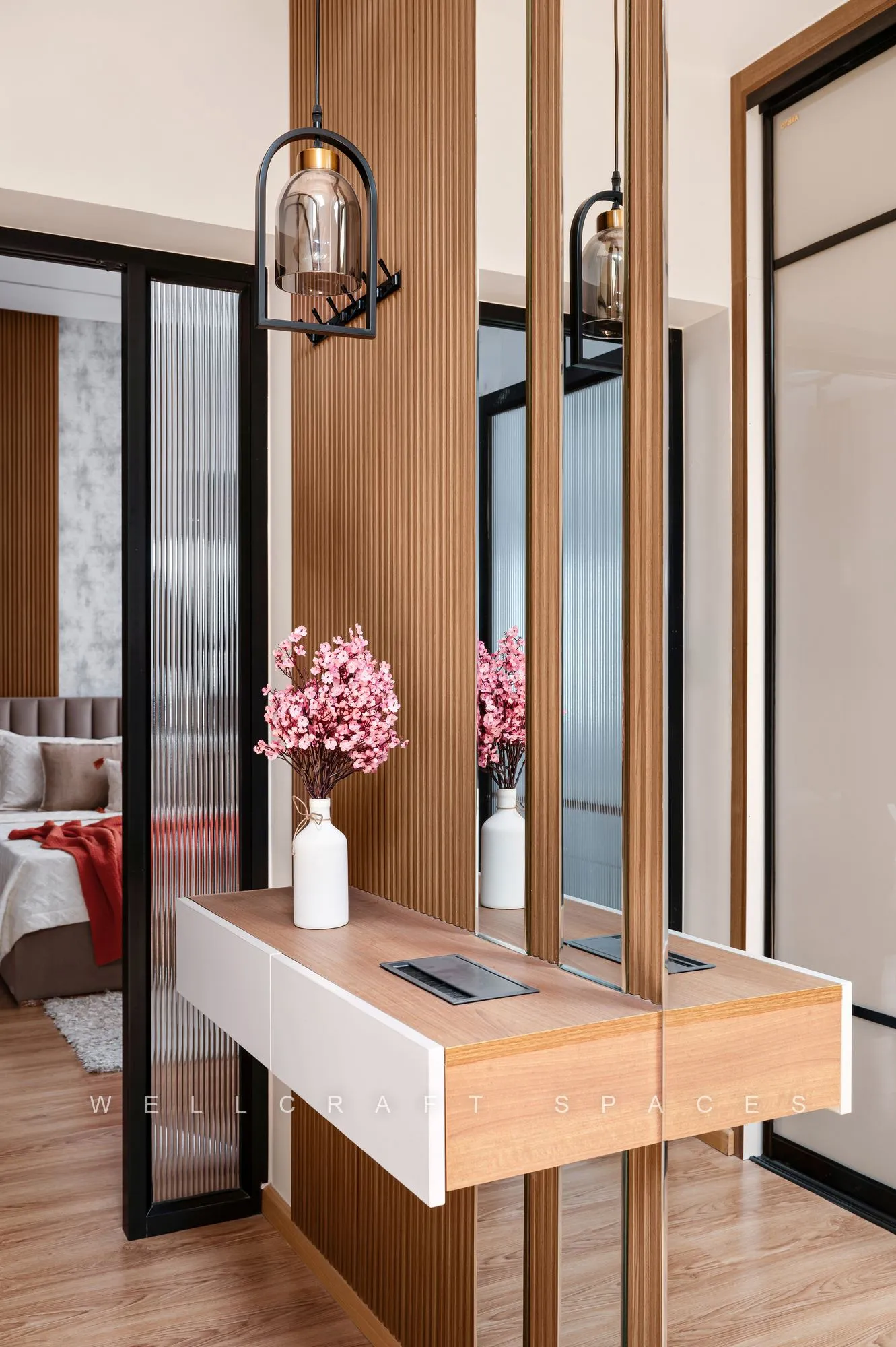 Dressing corner with a floating white and walnut vanity, a black metal and glass partition, mirrored wardrobe fronts and a smoked-glass pendant.