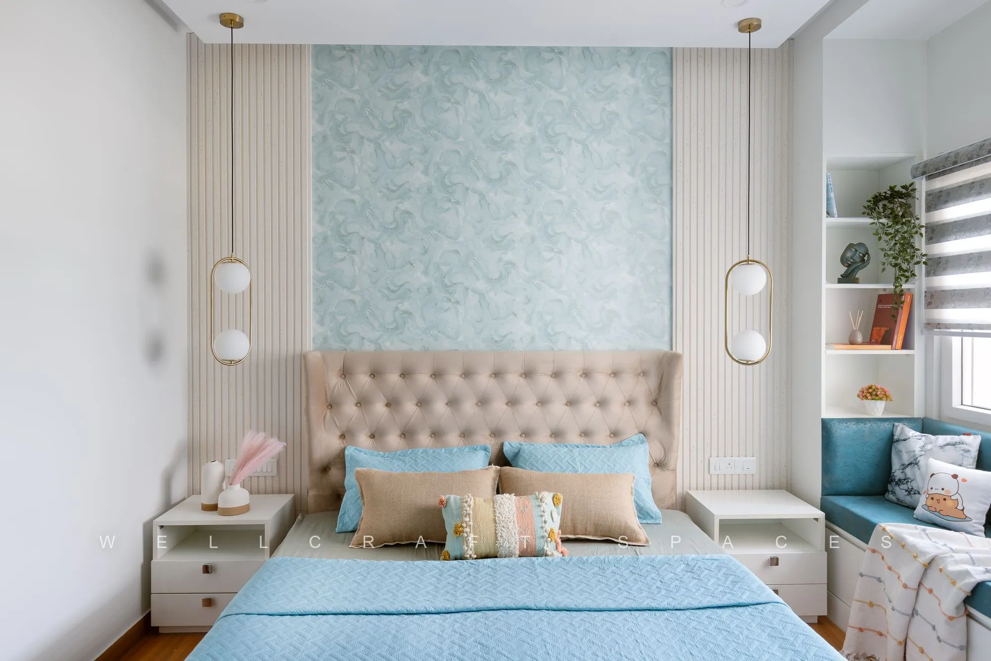 Master bed with a tufted cream headboard against teal damask wallpaper and fluted panelling, framed by matching capsule pendant lights.