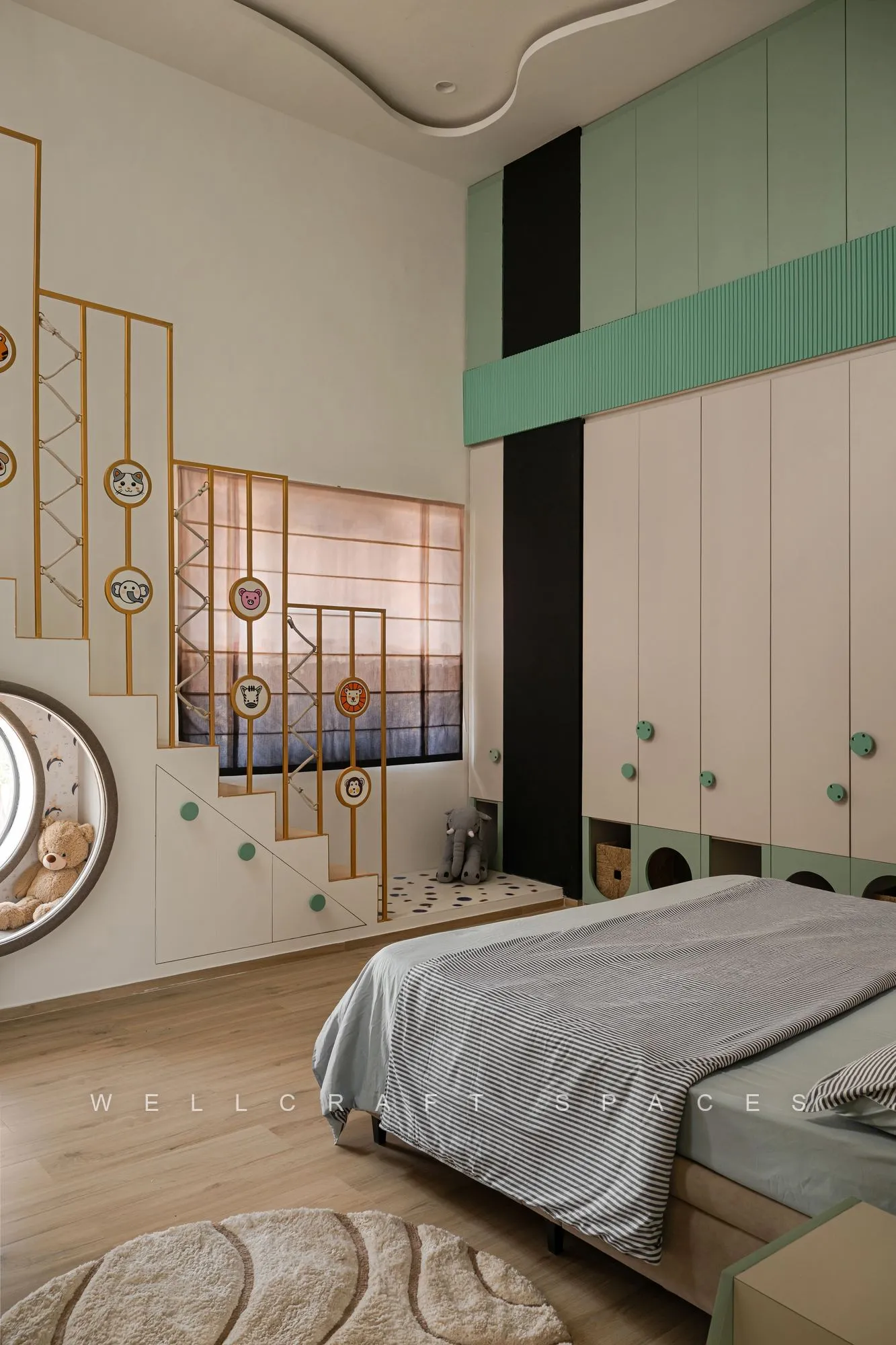 Bedroom with a mint and brass fretwork screen beside the bed, tall cream wardrobes and a patterned rug on timber flooring.
