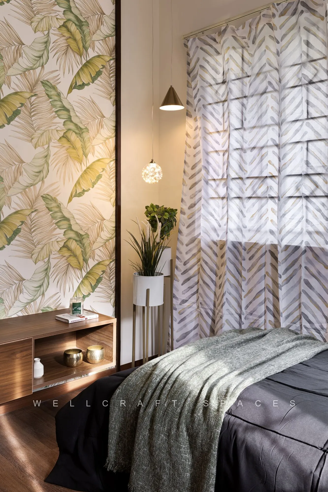 Parents' bedroom with a tropical leaf-print feature wall, a charcoal bedspread with a sage throw, a slim wall lamp and a chevron-patterned sheer curtain.