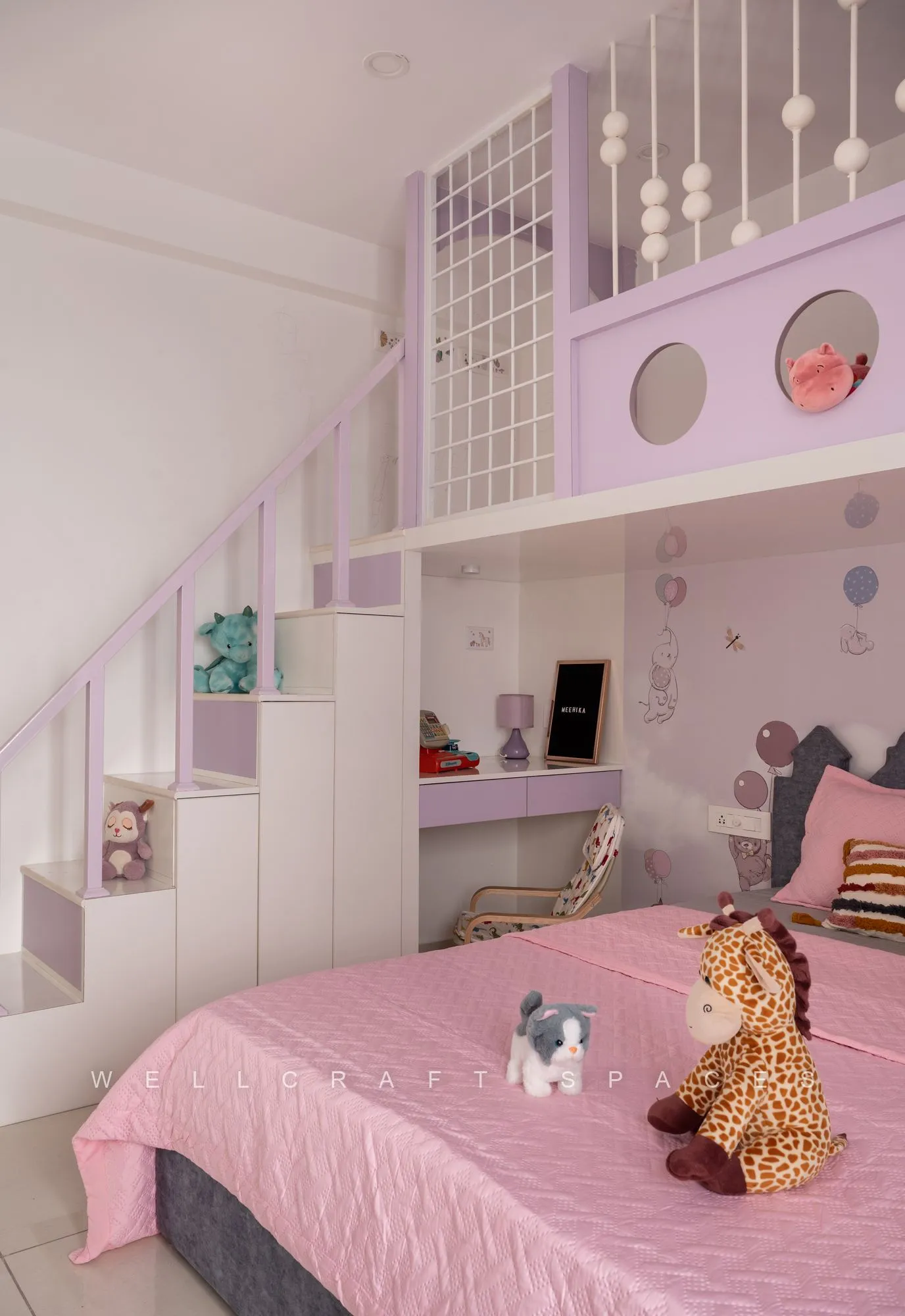 Kids' room showing the stepped stair to the lilac mezzanine bunk, a built-in study desk and open shelves of soft toys.