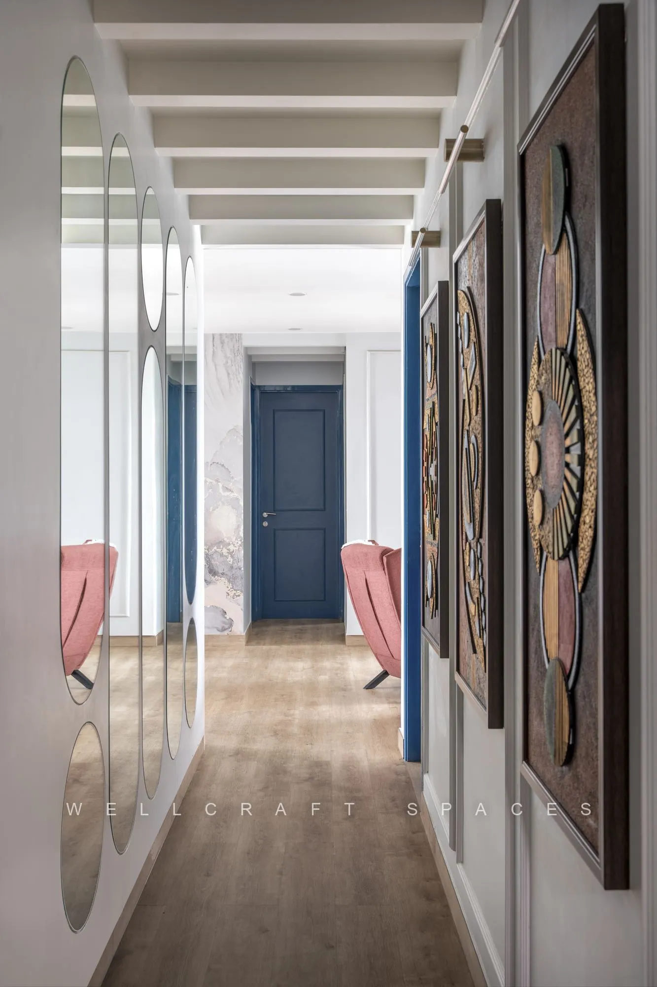 Living room TV wall in perforated tan panelling, with a part-open door revealing a peach-tiled bathroom vanity and mirror beyond.